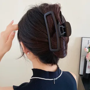 Elégante pince à cheveux rectangulaire creuse noir mat sur le chignon d'une femme