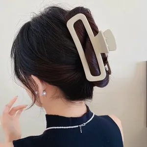 Vue détaillée d'une grande pince à cheveux en acrylique beige mat pour un chignon élégant