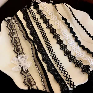 Detailed view of multiple black and white lace chokers featuring intricate floral patterns and bows