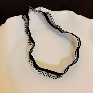 Elegant black mesh lace choker necklace detail showing delicate wavy edges on a plate
