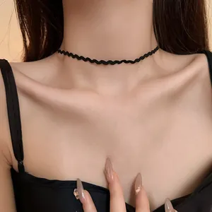 Close-up of a minimalist wavy black choker necklace on a female neck for dark aesthetic
