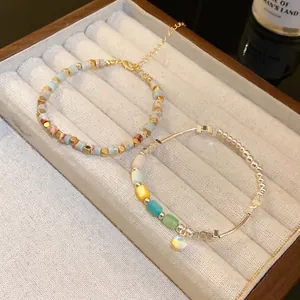 Elegant set of colorful beaded bracelets with cylindrical charms in a wooden jewelry box
