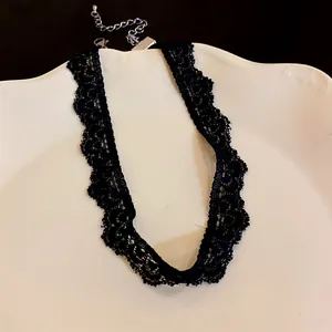 Close-up of elegant black lace choker necklace with vintage scalloped edges