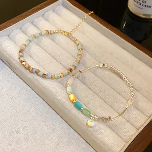 Close-up of colorful cylindrical bead bracelets with gold and silver accents in a jewelry box