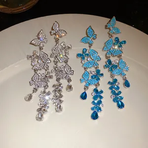 Elegant butterfly tassel earrings with sparkling rhinestones and blue stones details.