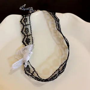 Close-up of black mesh lace choker necklace with a white bow detail and extender chain