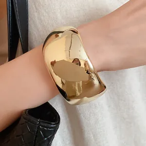 Close-up of a minimalist chunky gold resin cuff bracelet worn on the wrist for a stylish look