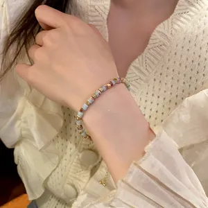 Close-up of a colorful cylindrical beaded bracelet worn on a female wrist.