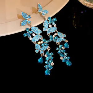 Detailed view of blue butterfly tassel earrings with sparkling rhinestones and beads.