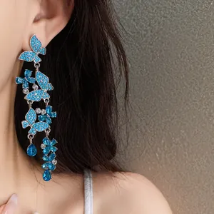 Close-up detail of elegant long blue butterfly tassel earrings with sparkling rhinestones