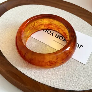 Detailed macro view of an amber resin geometric circular bangle with marble texture