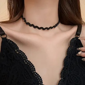Detailed view of a minimalist black wavy lace choker necklace worn by a female model