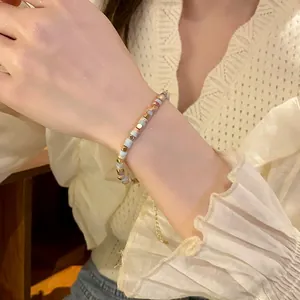 Close-up detail of a colorful cylindrical bead bracelet worn on a model's wrist