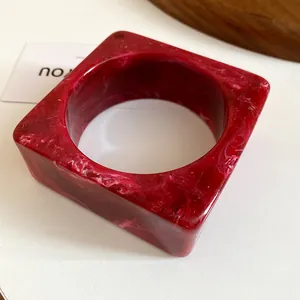 Macro view of red marble pattern resin bangle with geometric square outer shape