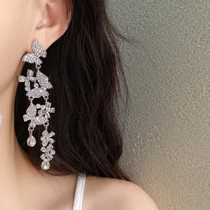 Detailed view of elegant silver color butterfly tassel dangle earrings on a model's ear