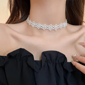 Detailed macro view of a delicate white floral lace choker necklace worn by a model