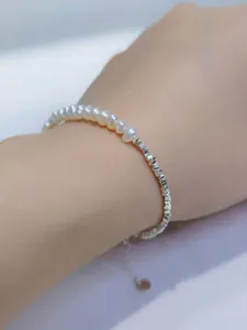 Bracciale di perle barocche e perle d'argento sfaccettate sul polso