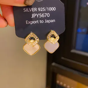 Detail of vintage palace style earrings with crystal-set diamonds and shell inlay