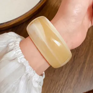 Elegante bracciale rigido vintage in acrilico con trama marmorizzata ambrata al polso