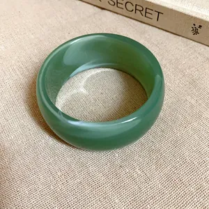 Dettaglio dell'elegante motivo marmorizzato su un ampio bracciale vintage in acrilico verde
