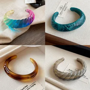 Stylish chunky resin cuff bracelets with a twisted design in various marble and gradient colors