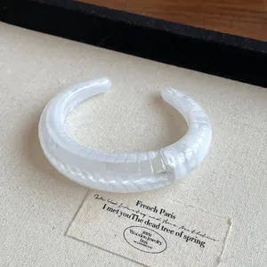 Elegant boutique white marbled resin open cuff bracelet with geometric textured pattern