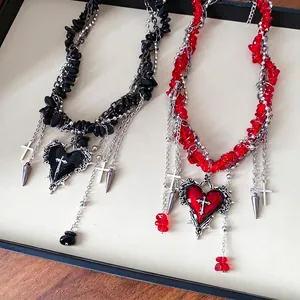 Gothic heart cross necklace featuring irregular stone beads and dangling metallic spikes