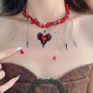 Detail view of gothic choker featuring irregular red stones and heart cross pendant