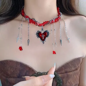 Detail of red crushed stone beaded heart necklace with silver cross pendants
