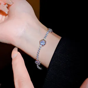 Gros plan d'un bracelet fleur en zircone cubique étincelant sur un poignet en noir