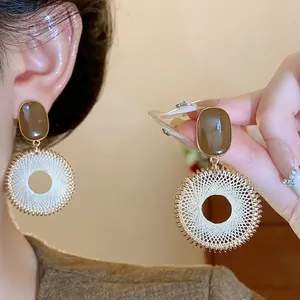 Retro ethnic style silver needle earrings featuring a woven lattice circular pattern