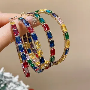 Nahaufnahme von lebhaften bunten Regenbogen-Zirkonia-Ohrringen mit elegantem Gold-Finish