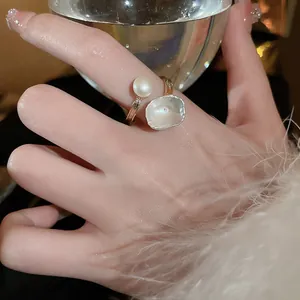 Gros plan sur une bague fleur à quatre pétales dorée ornée de perles d'eau douce naturelles
