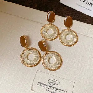 Detail showing vintage mesh circle drop earrings with brown studs and silver needles