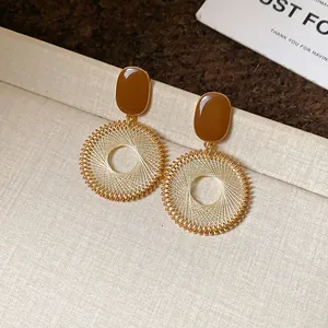 Detailed view of vintage ethnic-style earrings with golden grid-woven circle design