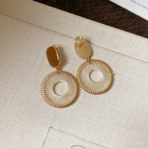 Detailed view of vintage gold-tone earrings with circular mesh woven drop design