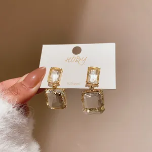 Detail shot of elegant transparent square crystal earrings with 925 silver post design