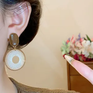 Close-up detail of vintage round mesh woven earrings with brown oval studs on ear