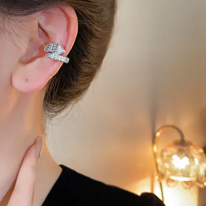 Primer plano de un ear cuff de serpiente con circonitas, lucido con elegancia en el oído