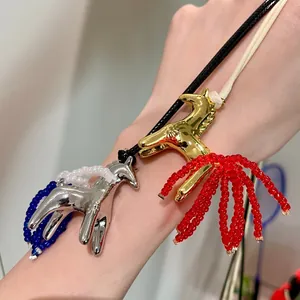 Detailed macro view of golden and silver pony pendants with vibrant beaded tassels