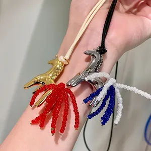 Close-up of horse-shaped pendants with colorful bead tassels on adjustable wax cords
