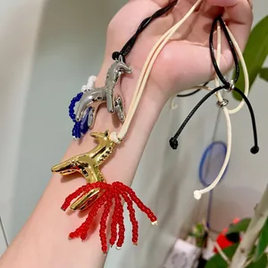 Detailed view of vintage horse pendant necklaces with beaded tassels on wax ropes
