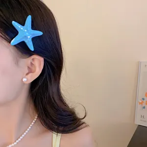 Nahaufnahme einer blauen Seestern-Haarklammer aus Acryl bei einem sommerlichen Look