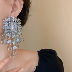 Close-up of exaggerated square glass bead tassel earrings with shimmering crystals