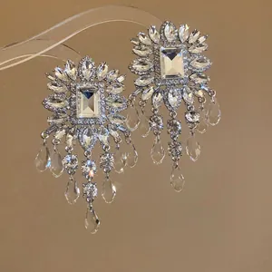 Detailed view of luxury rhinestone tassel earrings featuring a rectangular crystal stone