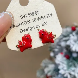 Close-up of festive red enamel horse earrings with S925 silver needles on a display card