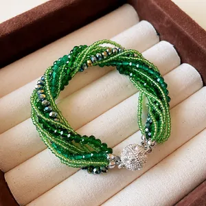 Close-up of multi-layer green crystal and seed bead bracelet with rhinestone clasp