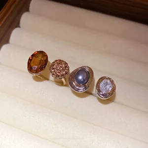 Set of four vintage-style open rings with stones displayed in a cream jewelry box