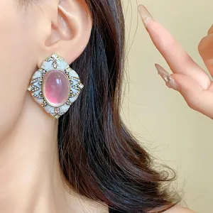 Primo piano di orecchini a lobo vintage con grande pietra rosa e dettagli strass