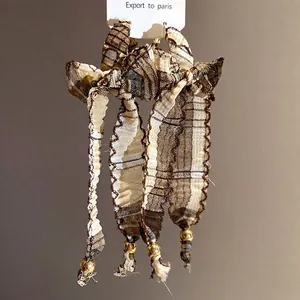 Retro ethnic style fabric bow tassel earrings with s925 silver needles and gold beads.